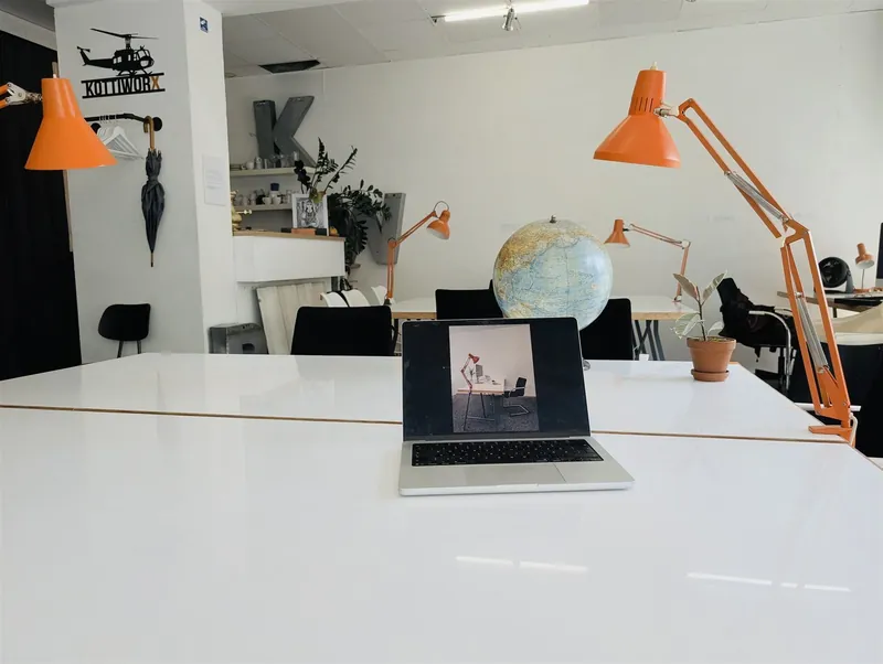White desk with laptop, globe and orange desk lamps in the KOTTIWORX coworking space, Berlin-Kreuzberg