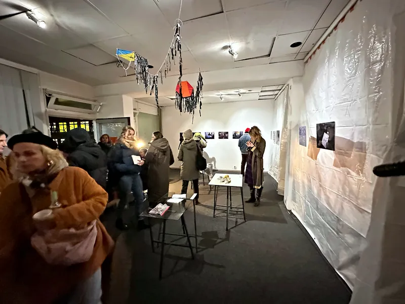 Evening photo exhibition in the KOTTIWORX event space at Kottbusser Tor, Berlin – visitors looking at photographs on the walls